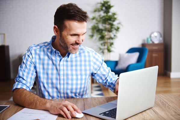 Smiling gamer playing on laptop