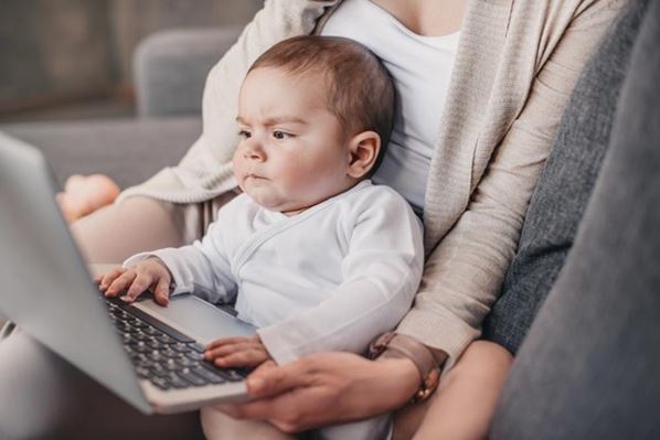 A serious baby looking at a laptop