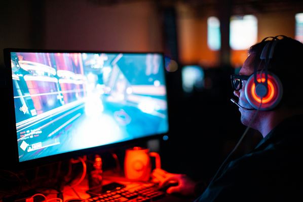 Gamer wearing headset and looking at computer screen