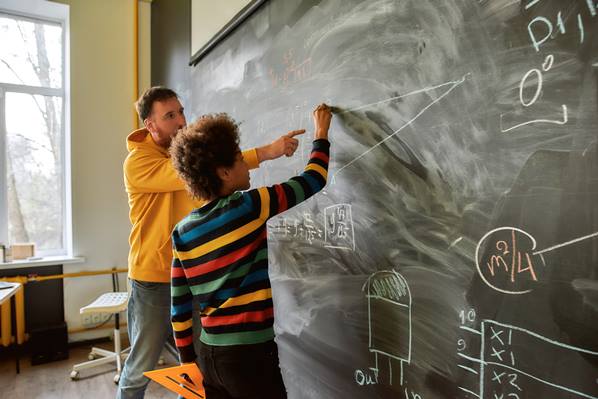 Teacher writing on a blackboard